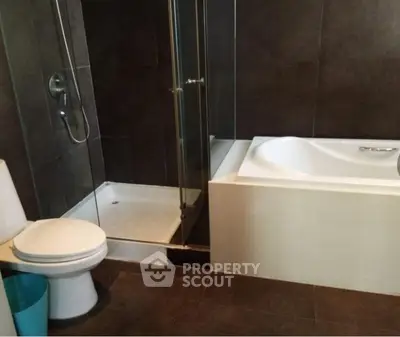Modern bathroom with shower and bathtub in sleek design.