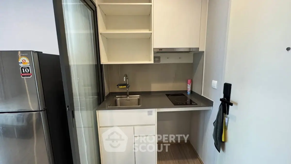 Compact modern kitchen with sleek cabinetry and stainless steel appliances