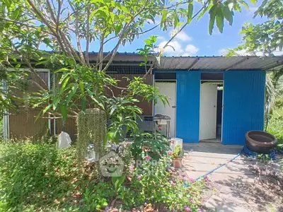 Charming rustic exterior with lush garden and vibrant blue doors, perfect for nature lovers seeking tranquility.