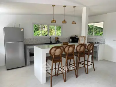 Modern kitchen with open layout, sleek countertops, and stylish bar stools in a bright, airy space.