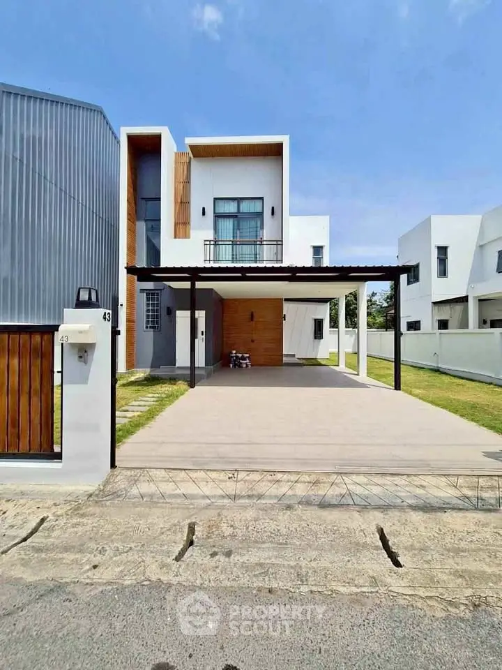 Modern two-story house with spacious driveway and sleek architectural design.