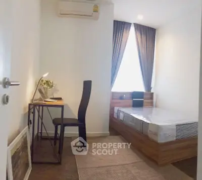 Cozy bedroom with study desk and modern decor in a compact space.