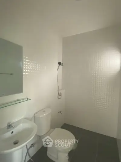 Modern minimalist bathroom with sleek fixtures and white tiles, perfect for a contemporary home.