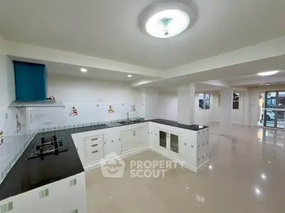 Spacious kitchen with sleek countertops and gas stove in modern open layout