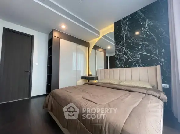 Luxurious bedroom with modern design and elegant marble accent wall.