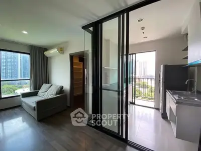 Modern apartment with open layout, large windows, and city view, featuring a sleek kitchen and cozy living area.