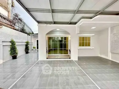 Spacious modern home entrance with sleek tiled patio and covered area.