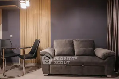 Modern living room with stylish gray sofa and elegant dining set
