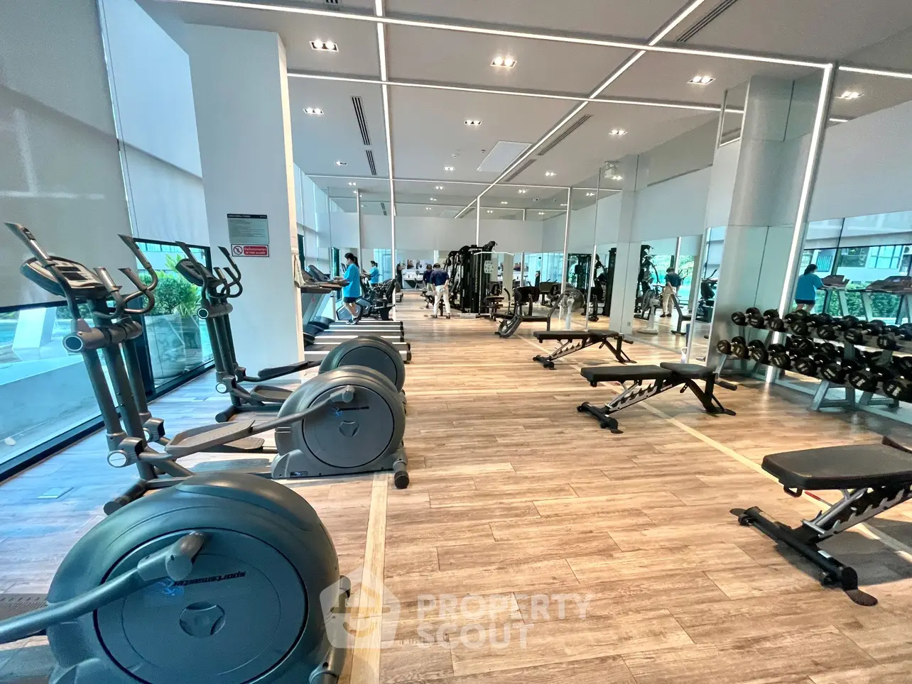Modern gym with state-of-the-art equipment and mirrored walls in a luxury residential building.