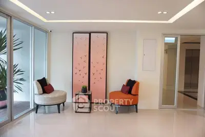 Stylish modern living area with elegant chairs and decorative panel, perfect for relaxation.