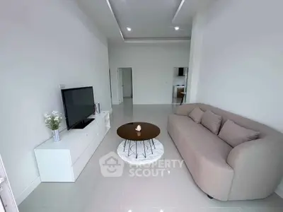 Modern living room with sleek design, featuring a cozy sofa, stylish coffee table, and flat-screen TV.