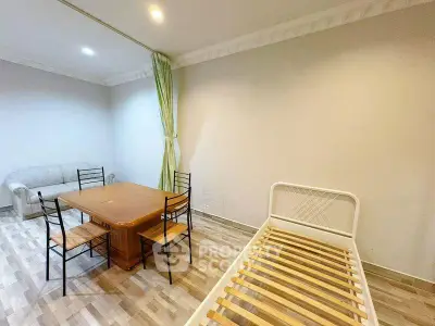 Spacious room with minimalist furniture and wooden flooring, ideal for versatile living arrangements.