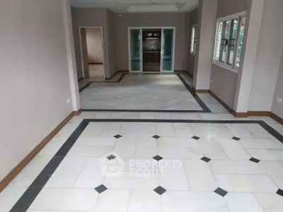 Spacious empty living room with elegant tile flooring and large windows
