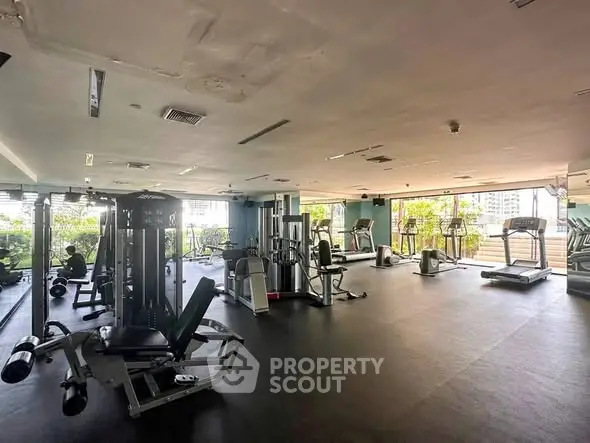 Spacious modern gym with state-of-the-art equipment and city view.