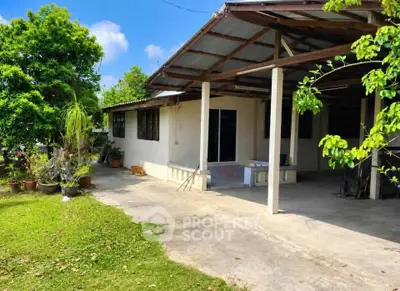 Charming single-story home with spacious outdoor area and lush greenery.