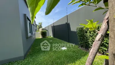 Spacious backyard with lush green lawn and privacy fence in modern home.