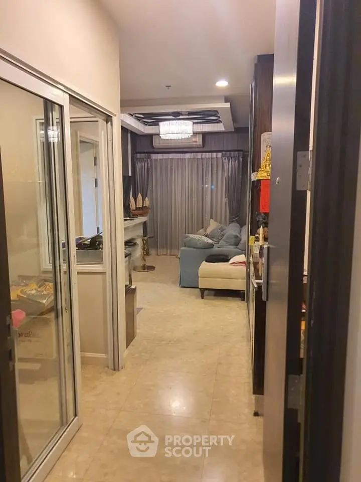 Stylish apartment hallway leading to a cozy living room with elegant decor and ambient lighting.