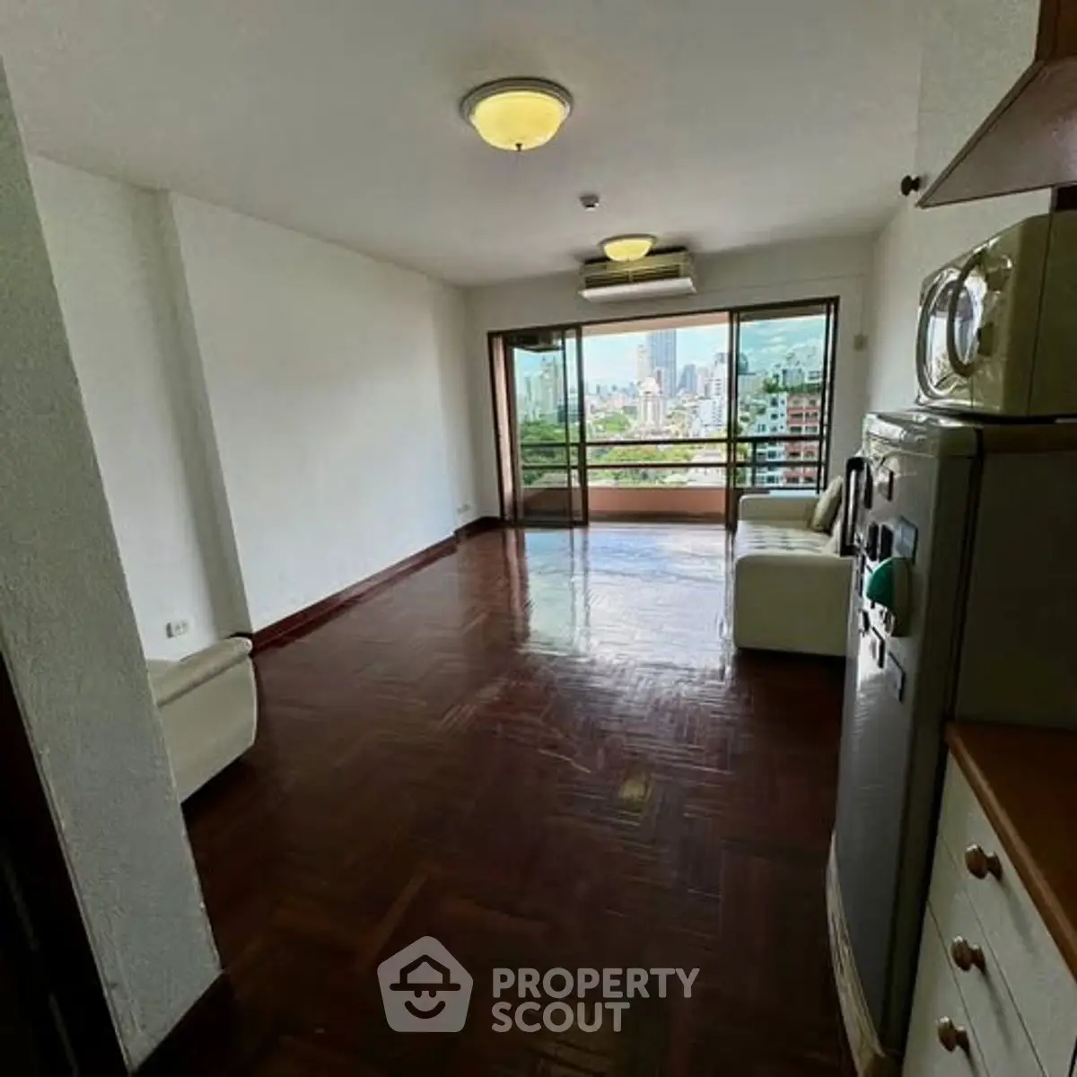 Spacious living room with city view and parquet flooring in modern apartment.