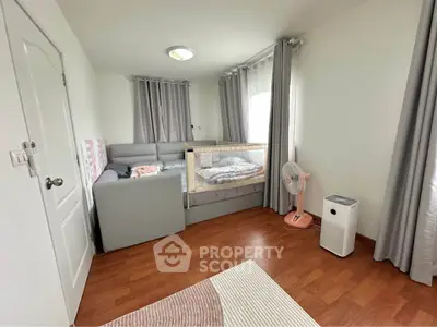 Cozy bedroom with crib, sofa, and air purifier, perfect for a small family.