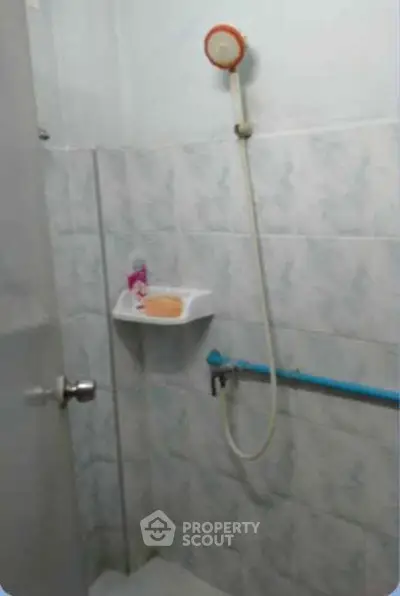 Compact bathroom with shower and tiled walls, ideal for small spaces.
