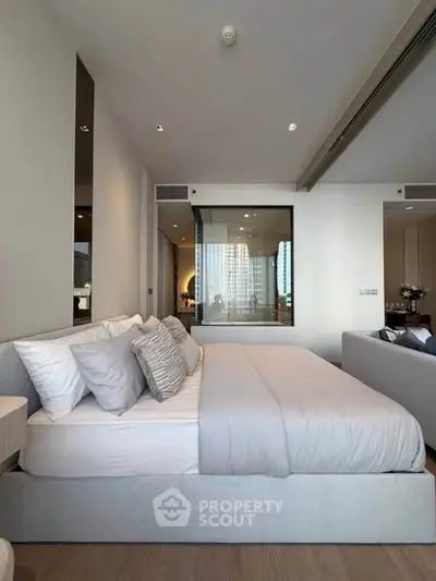 Luxurious modern bedroom with elegant decor and large windows offering city views.