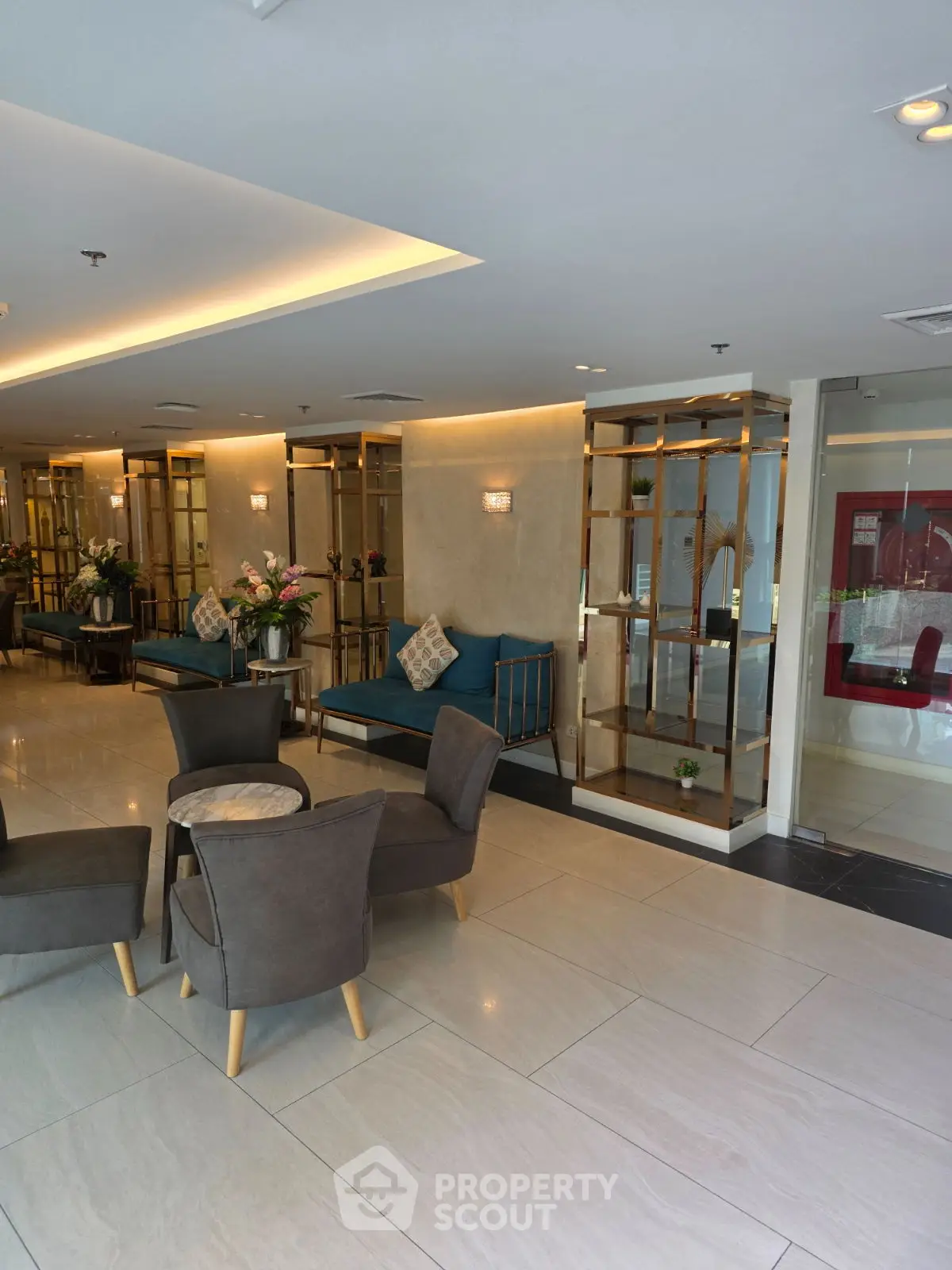 Elegant lobby with modern seating and decorative shelving in a luxurious building.