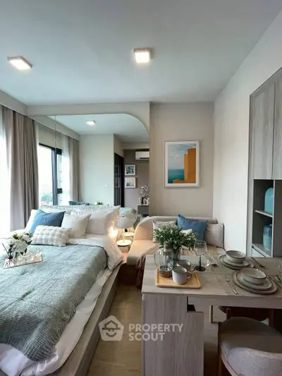 Modern studio apartment with cozy bedroom and dining area, featuring stylish decor and natural light.