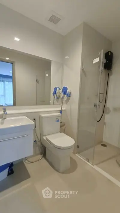 Modern bathroom with glass shower and sleek fixtures in a contemporary apartment.