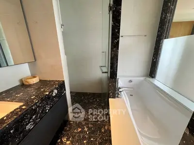 Luxurious bathroom with elegant black marble finishes and modern bathtub
