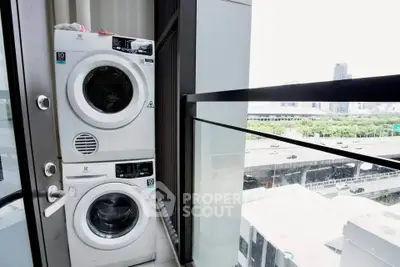 Modern balcony with stacked washer and dryer overlooking cityscape