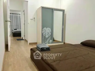 Cozy bedroom with modern wardrobe and comfortable bedding in a minimalist design.