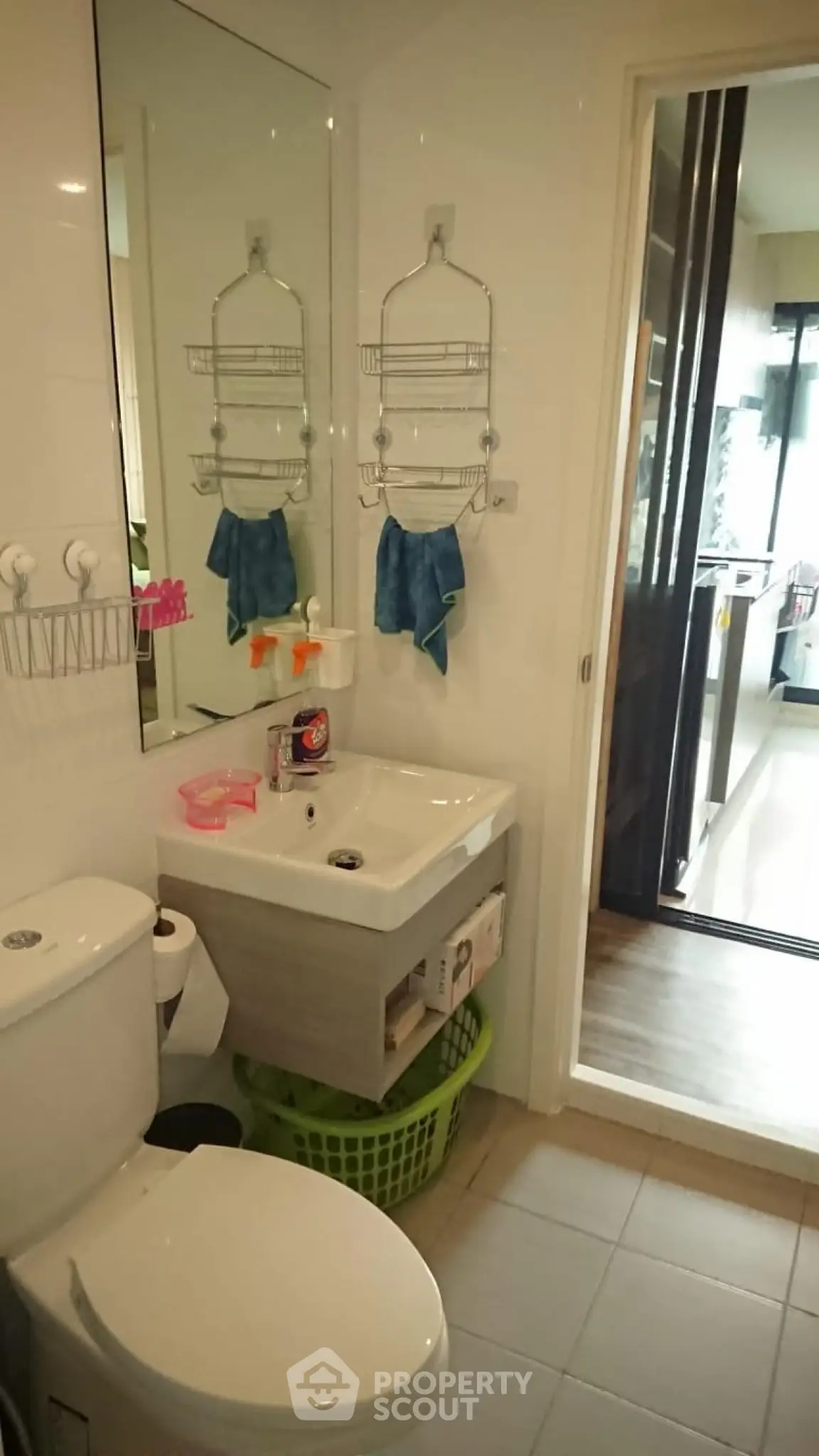 Compact bathroom with modern fixtures and adjacent kitchen view