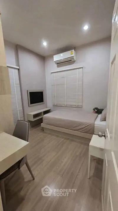 Cozy bedroom with modern decor and air conditioning, perfect for a comfortable living experience.