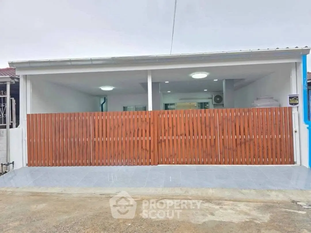 Modern single-story house with wooden fence and spacious driveway