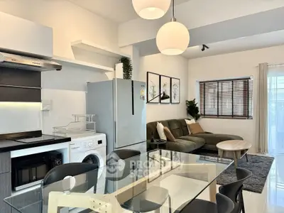 Modern open-plan living room and kitchen with stylish decor and natural light.