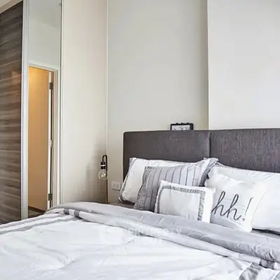 Modern bedroom with stylish decor and cozy bedding in a contemporary apartment.