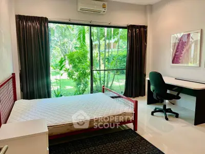 Bright bedroom with garden view, featuring modern furniture and large window for natural light.