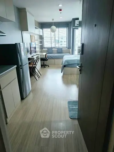 Modern studio apartment with open layout, featuring a cozy bedroom and compact kitchen.