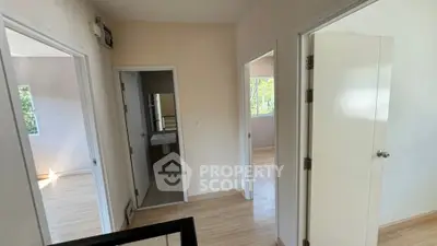 Bright hallway with multiple doors leading to rooms in a modern home