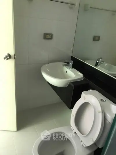 Compact bathroom with modern sink and toilet, ideal for efficient space utilization.