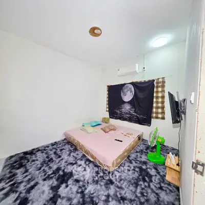 Cozy bedroom with modern decor and plush carpet, featuring a wall-mounted TV and air conditioning.