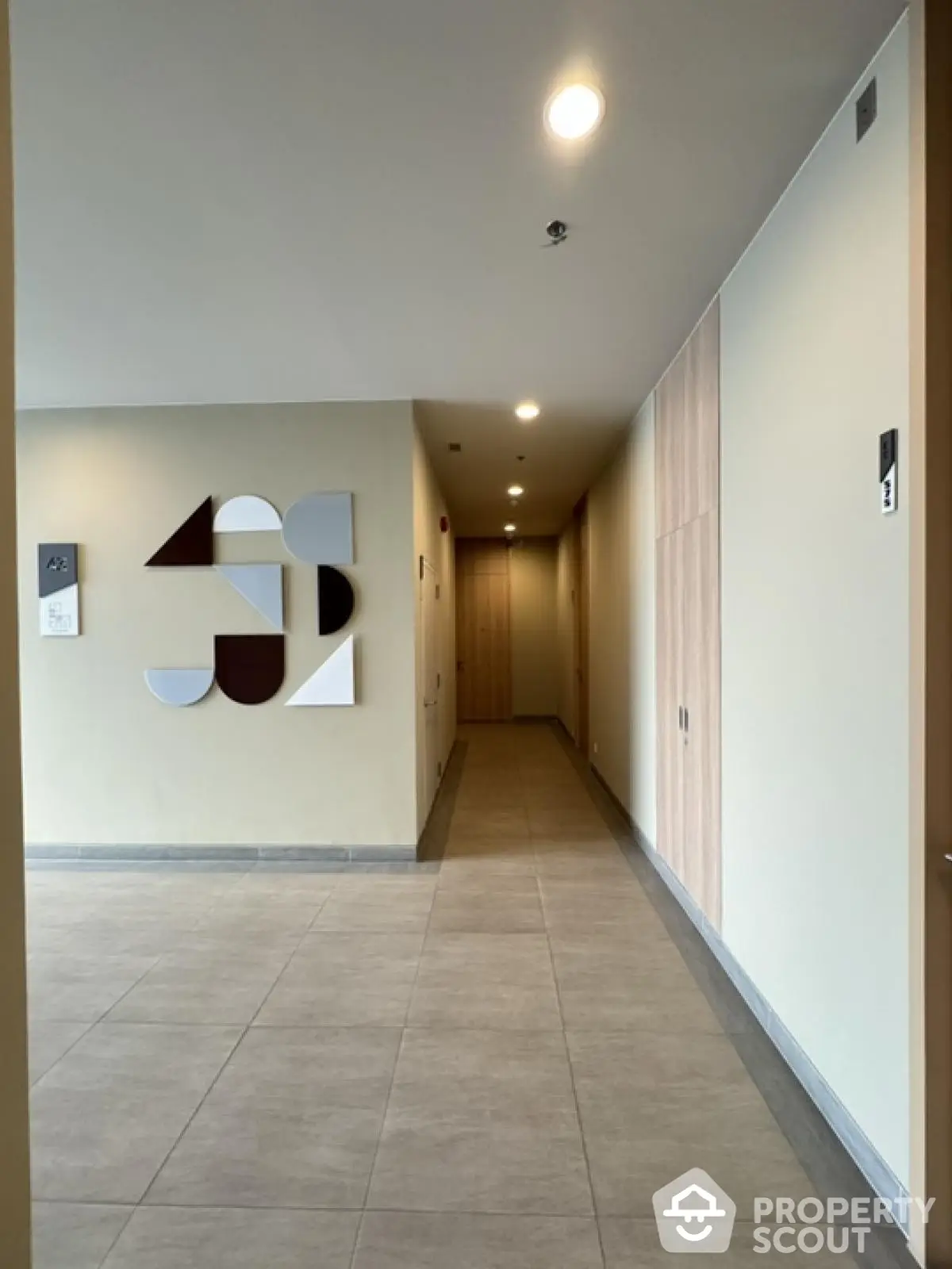 Modern apartment hallway with stylish wall art and recessed lighting