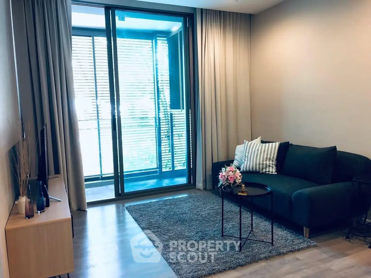 Modern living room with cozy sofa and large window balcony view.