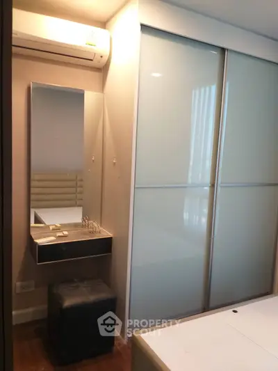 Modern bedroom with sleek closet and vanity area, featuring a minimalist design.