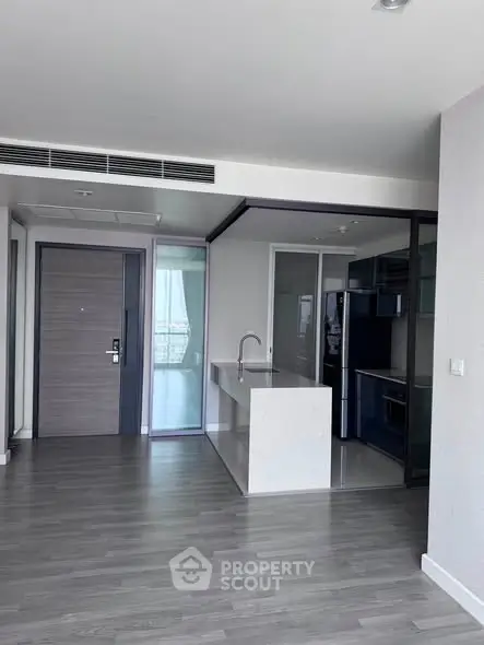 Modern apartment interior with sleek kitchen and open layout, featuring stylish flooring and contemporary design.
