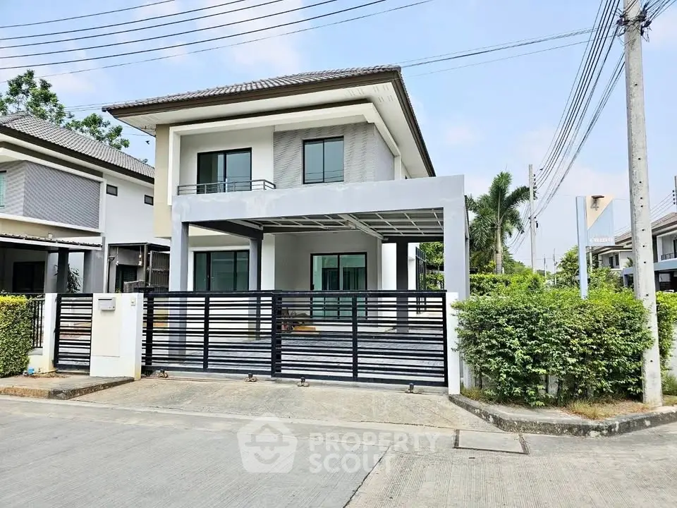 Modern two-story house with gated entrance and driveway in suburban neighborhood.