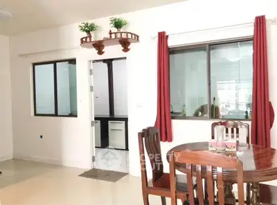 Bright dining area with wooden furniture and red curtains in a modern apartment.