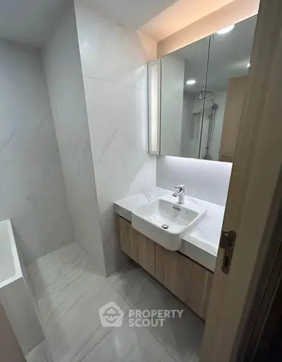 Modern bathroom with sleek design and elegant fixtures, featuring a stylish sink and mirrored cabinet.