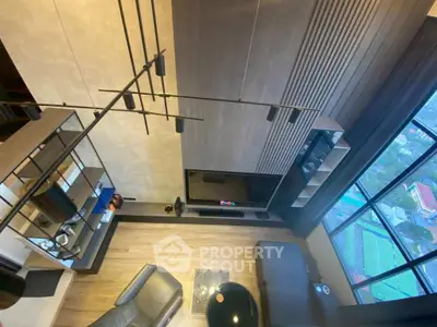 Modern living room with high ceiling and large windows offering a stunning city view.