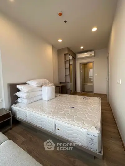 Modern bedroom with new mattress and wooden flooring in a stylish apartment.